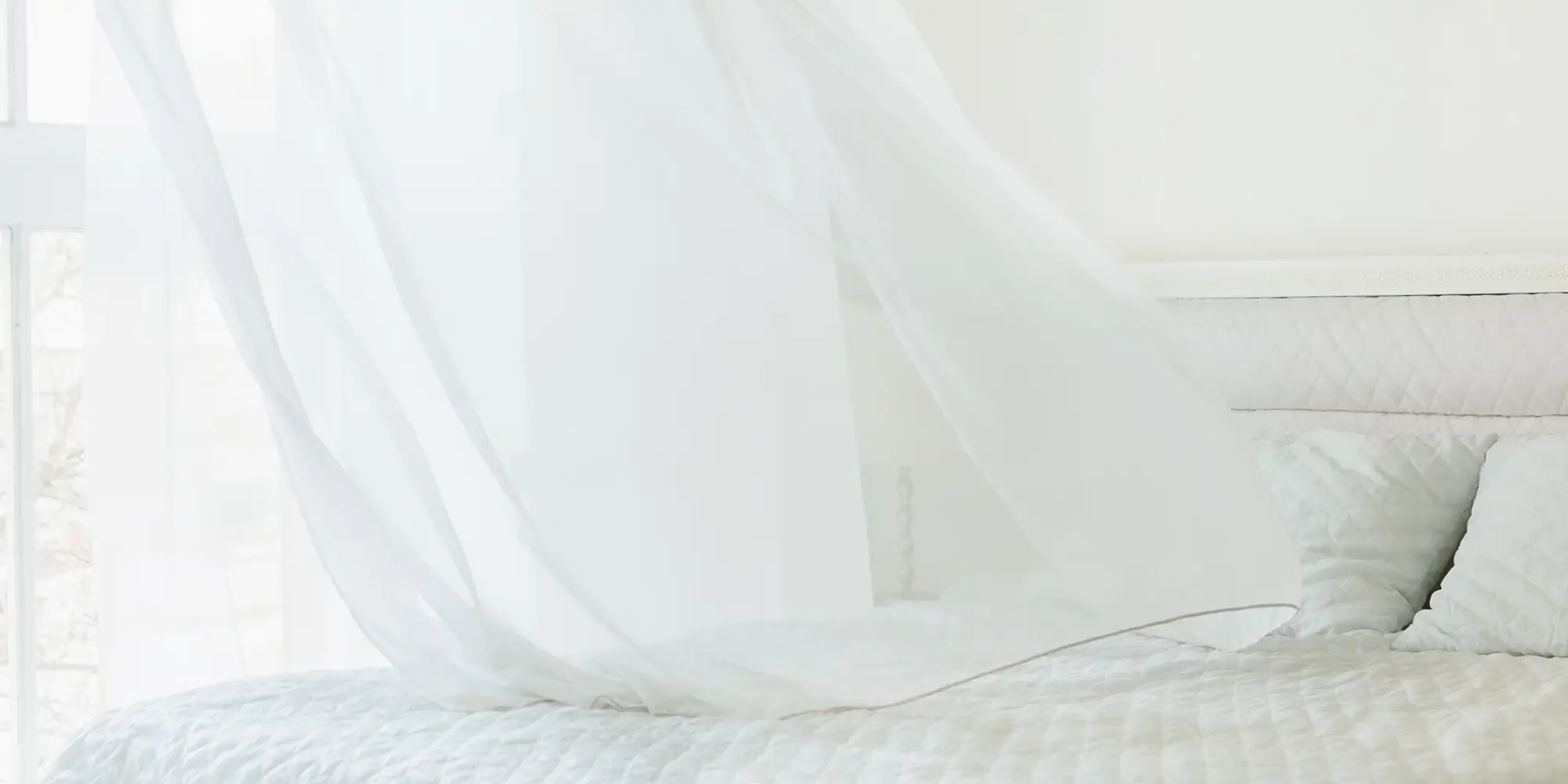 Slaapkamer met wapperende gordijnen